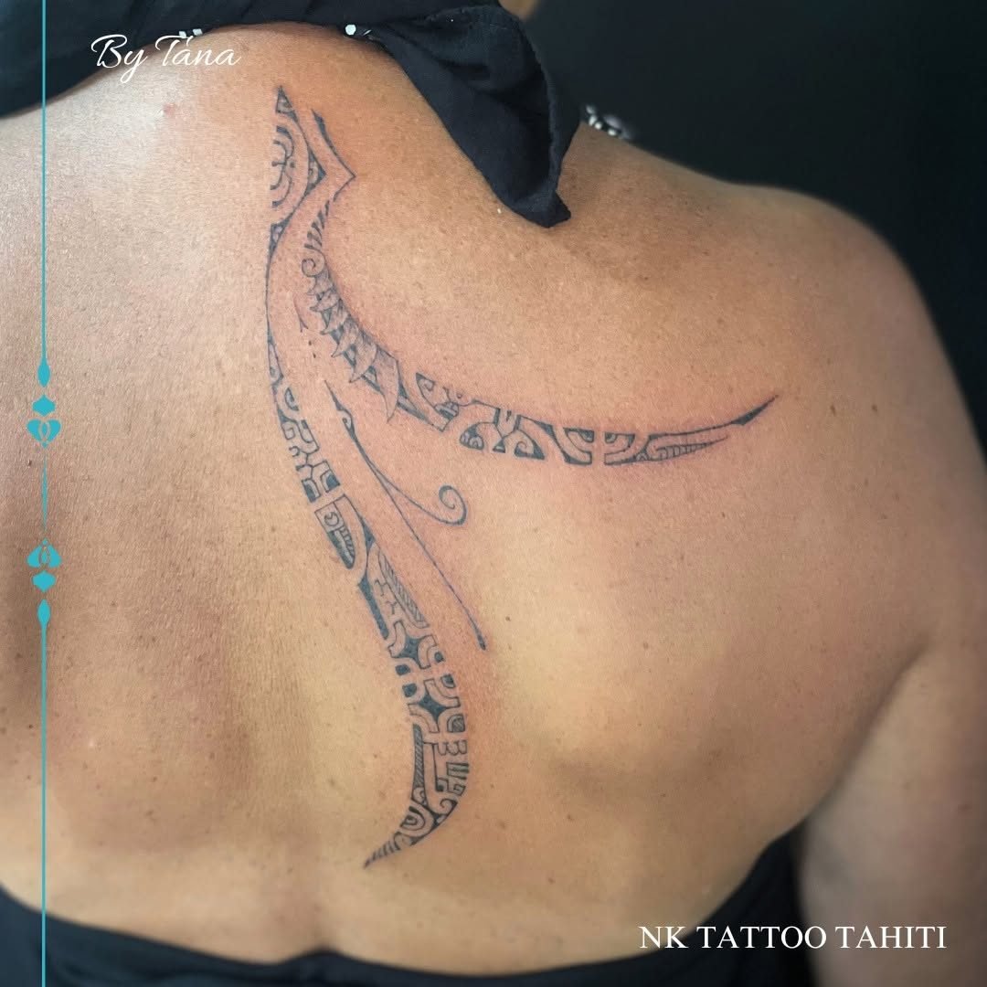 Tatouage fin en arc sur l'omoplate et le haut du dos